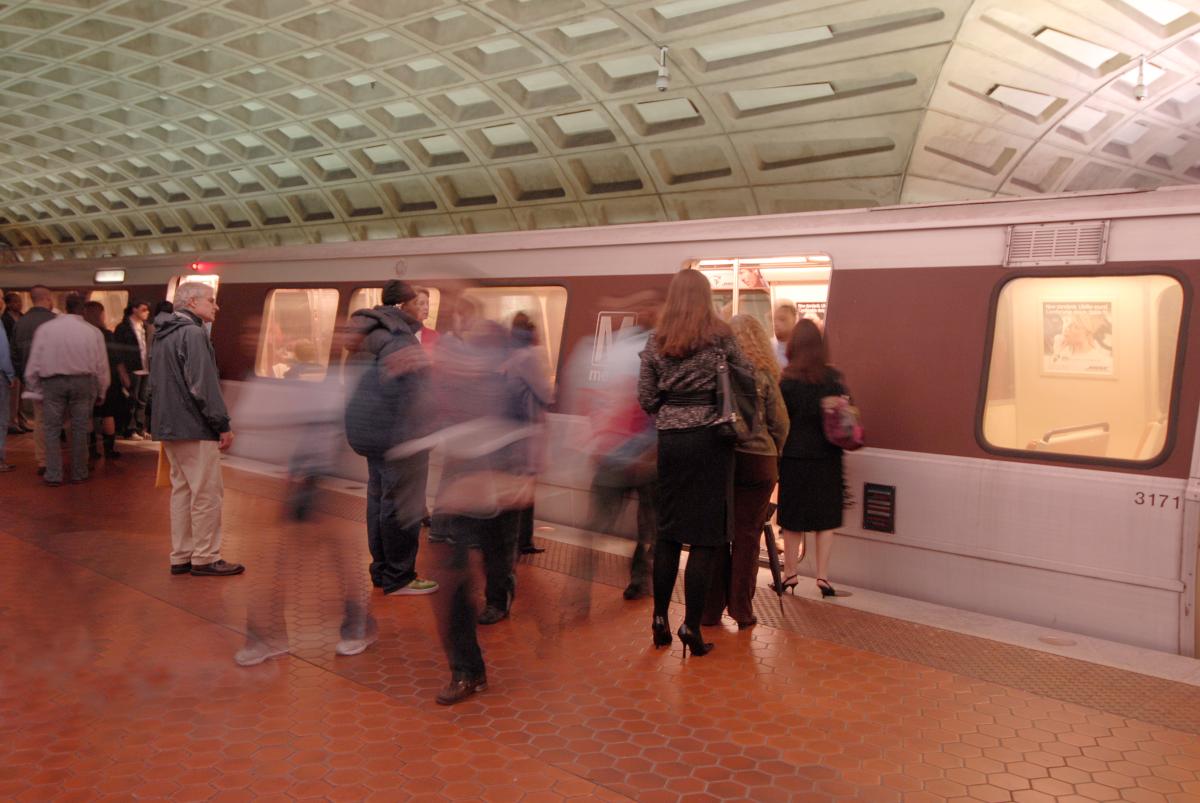 Passengers boarding a Metro train at Metro Center Station platform.
