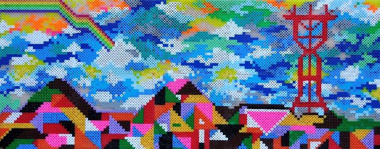 Pixelated digital art depicting colorful buildings and a pagoda tower under a blue sky with clouds.