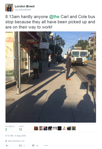 Empty bus stop on street with few pedestrians and passing vehicle, San Francisco