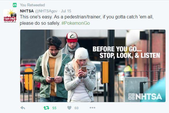 Three people looking at phones on a city street with traffic light and "Stop, Look, & Listen" safety message.