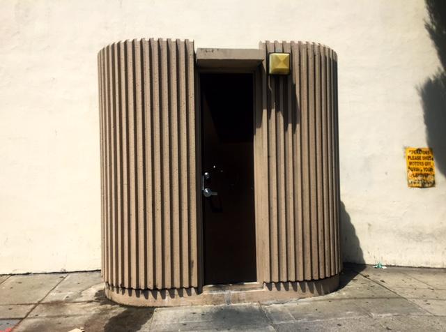 Crenulated oval beige operator convenience station with open door at North Point and Van Ness Avenue.