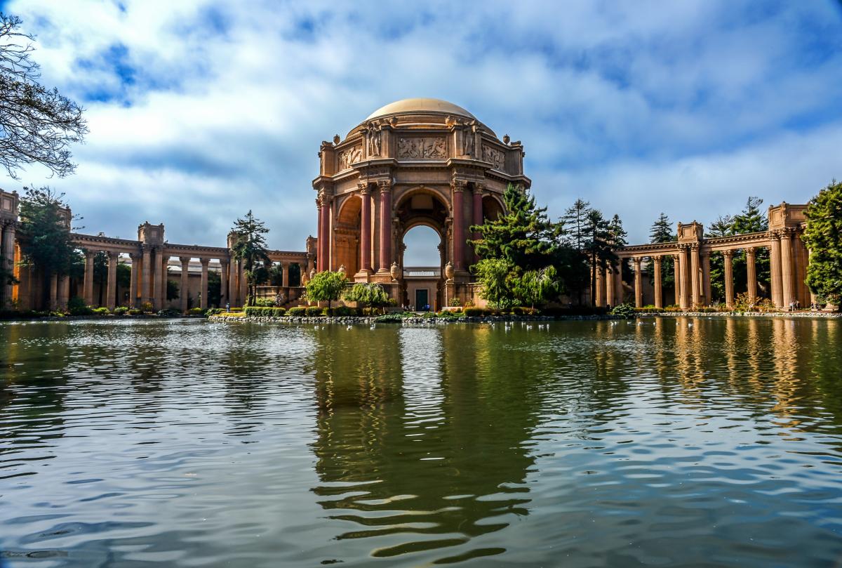 Palace of Fine Arts rotunda and colonnade reflected in pond under blue sky