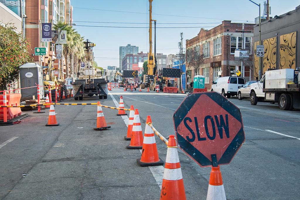 Construction cones and a SLOW sign block 4th Street near King Street during Central Subway track work.