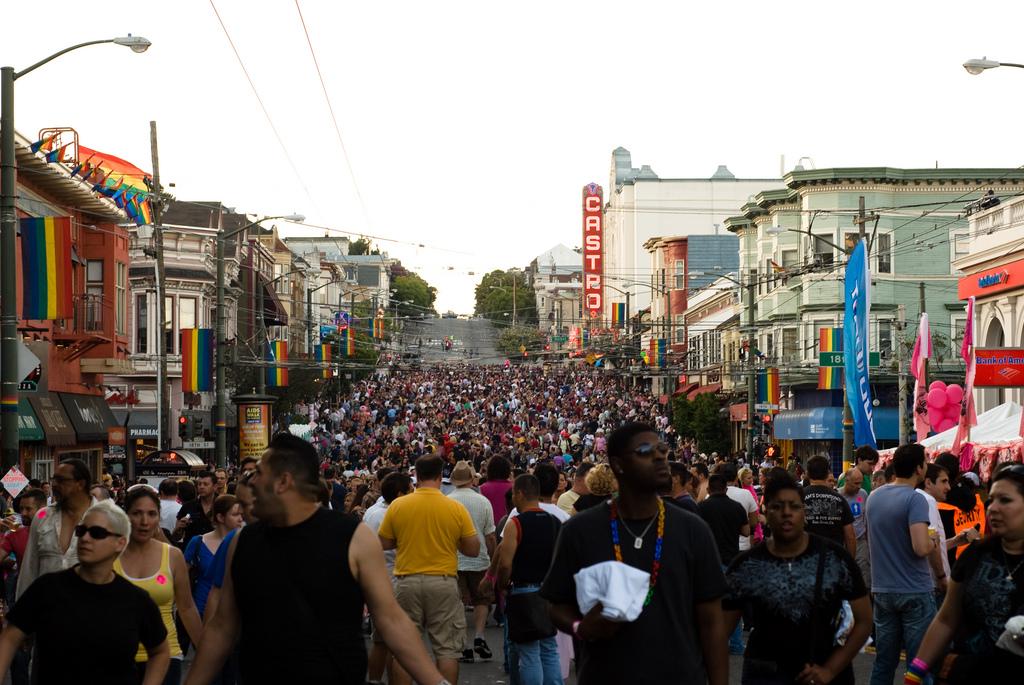 Large crowd of people filling Castro Street during Pride weekend celebration in San Francisco.