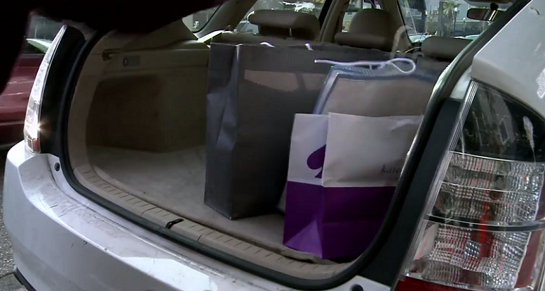 Open car trunk with shopping bags inside.