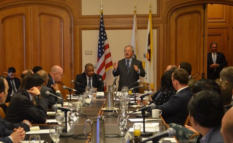 Mayor Ed Lee speaks at a conference table with government officials and US Transportation Secretary Anthony Foxx.