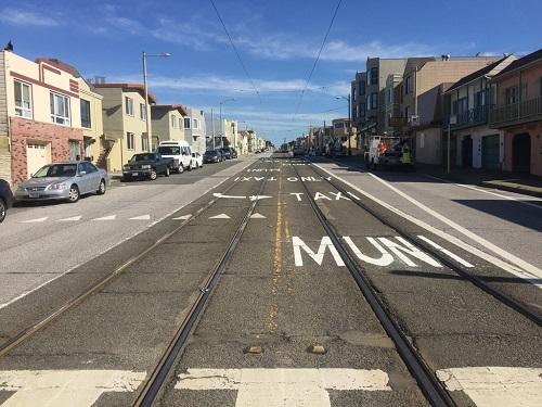 Transit-only lane with streetcar tracks and crosswalk markings on city street
