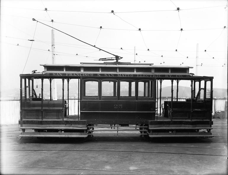 Black and white side view of an early electric streetcar numbered 25 with overhead trolley pole, circa 1903.