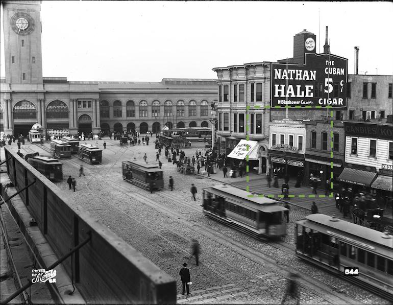 Cable cars on Market Street with historic buildings and street-level activity, circa early 1900s.