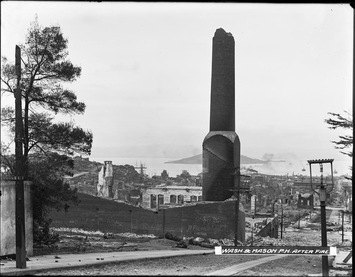 Damaged brick chimney standing amid ruins of Washington and Mason Car House after 1906 San Francisco earthquake and fire