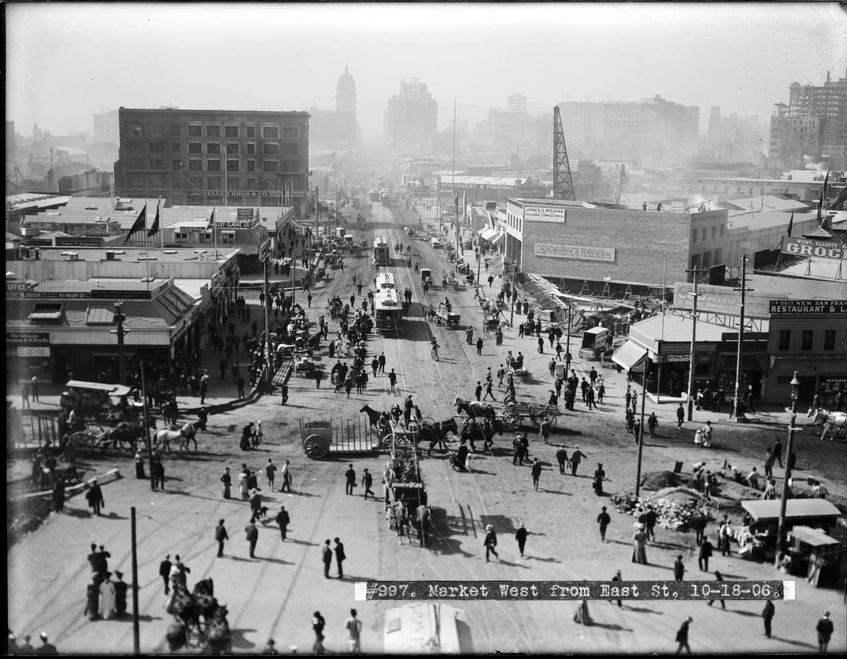Market West from East Street, October 18, 1906. Crowded street scene with pedestrians, buildings, and city skyline in background.