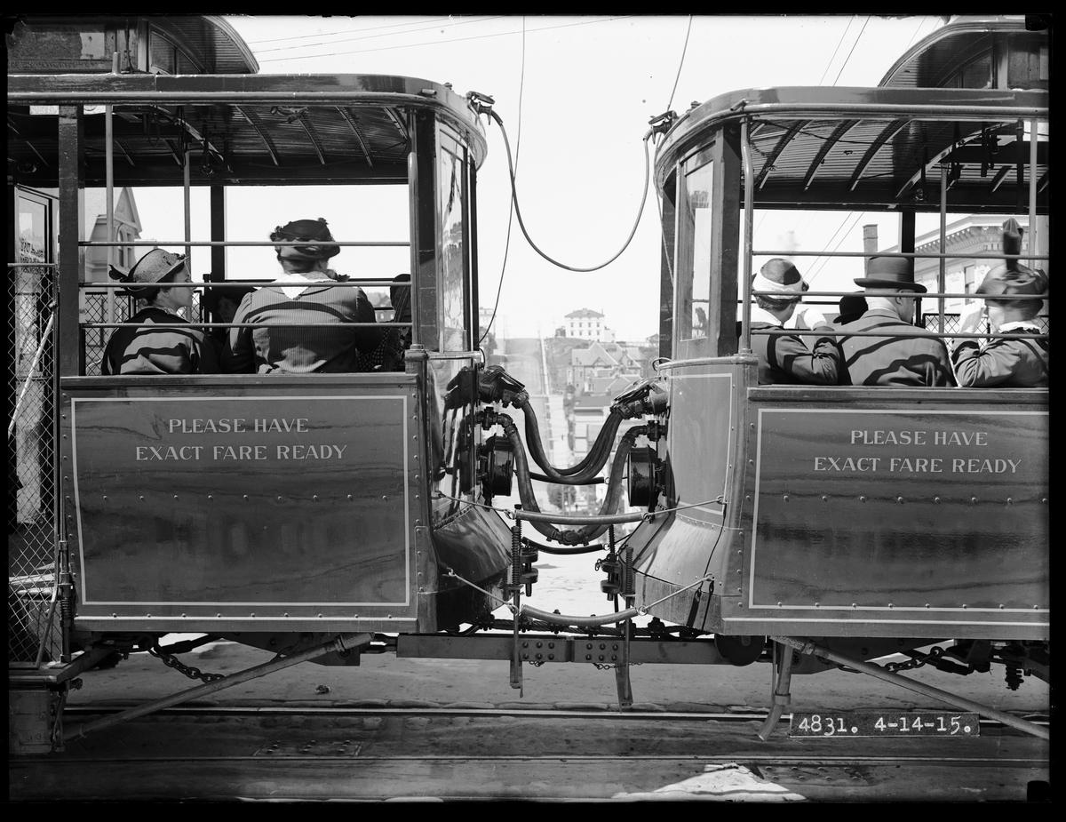 Two vintage streetcars connected by air coupling at Fillmore and Broadway Streets, San Francisco, 1915.