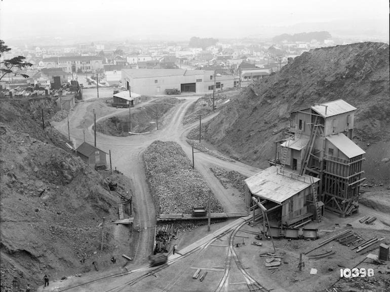 Daly's Quarry with loading facility and rail tracks, residential neighborhoods visible in background, 1926.