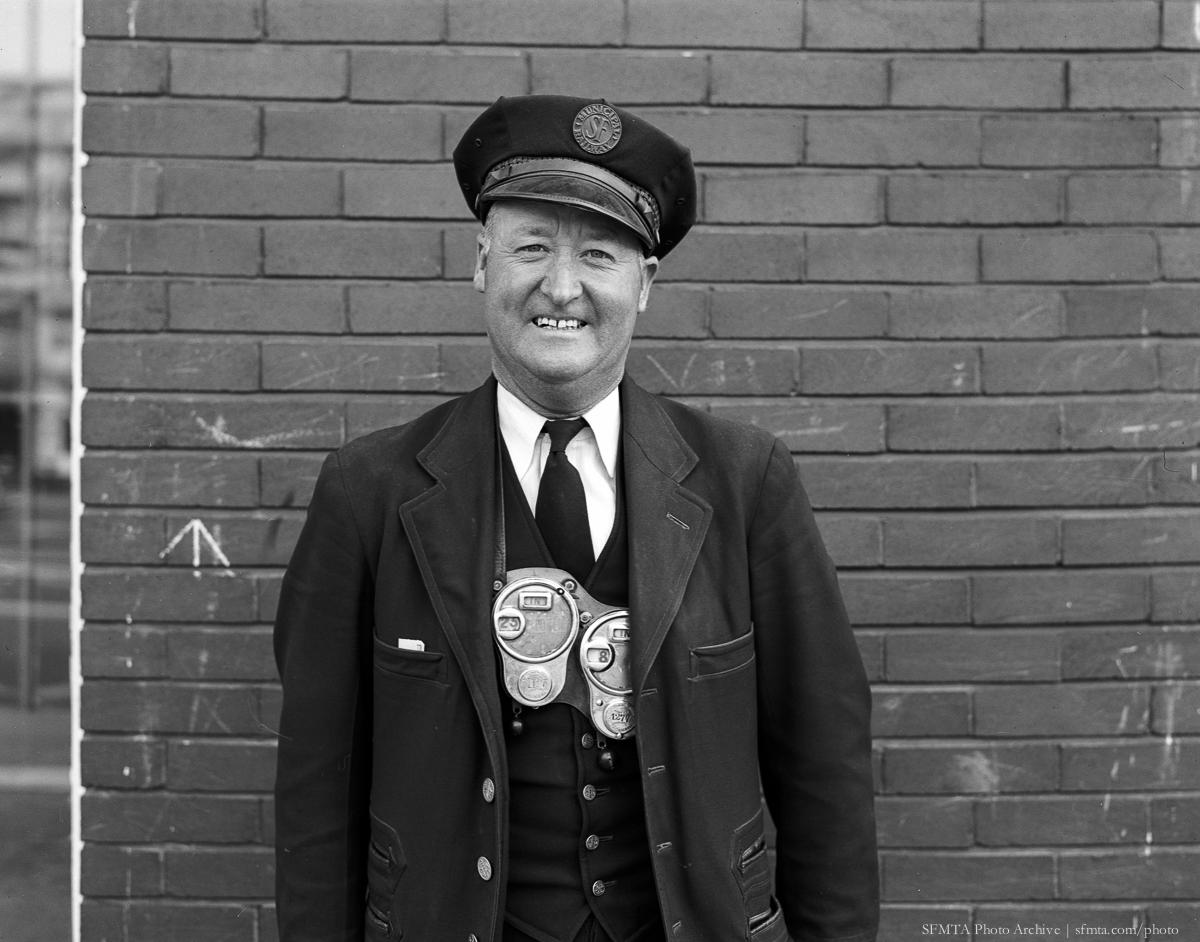 Smiling transit conductor in uniform holding vintage fare collection register, 1948