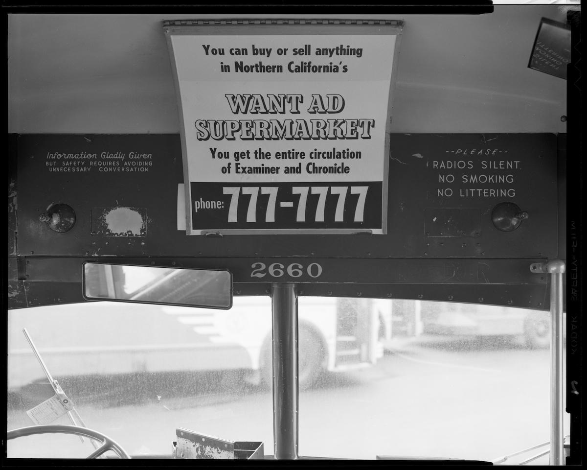 Bus interior from 1966 showing want ad supermarket advertisement and Information Gladly Given sign.