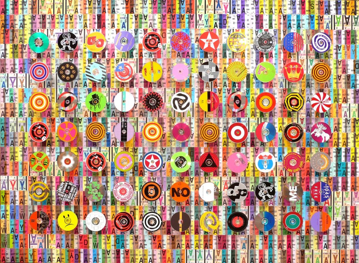 Colorful vinyl records and CDs arranged in a grid pattern on a background of repeated letters and text.