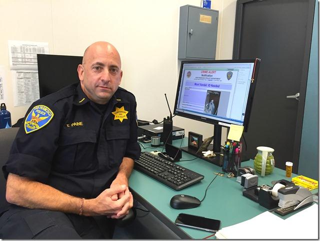 Transit police lieutenant at desk with computer displaying crime alert system