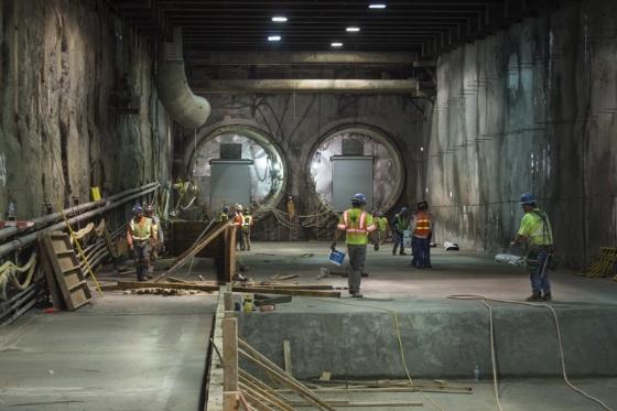 Workers in safety vests prepare tunnel portal construction on 4th Street between Harrison and Bryant streets.