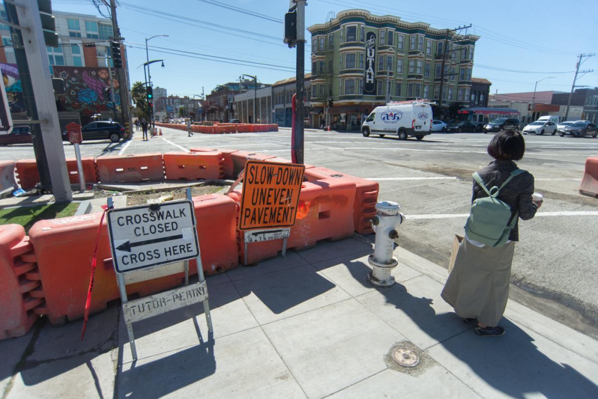 Intersection closed for repaving with orange barriers, warning signs, and pedestrian detour at 4th and Bryant.