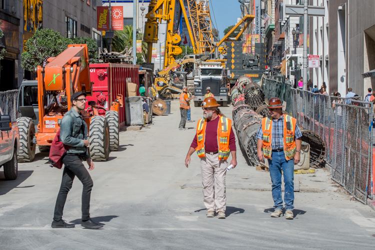 Construction workers and heavy equipment on Stockton Street at the future Union Square/Market Street Station site.