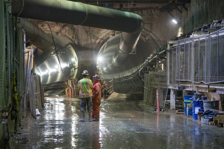 Workers in safety gear conduct tunneling operations beneath 4th and Harrison streets.