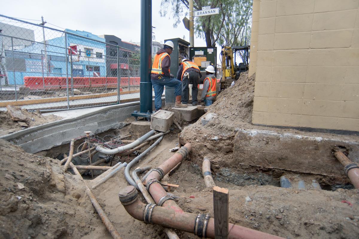 Construction workers install utility pipes and conduits at 4th and Brannan Streets.