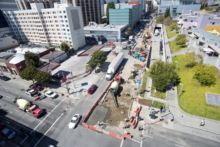 Aerial view of 4th Street construction site with crews, equipment, and traffic controls between Howard and Folsom streets.