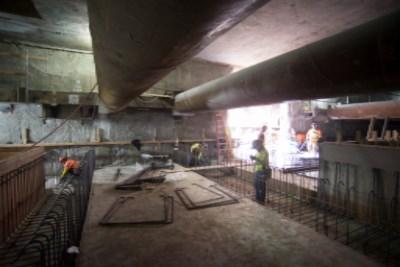 Construction work underway on 4th Street with concrete slab and temporary barriers visible under bridge.