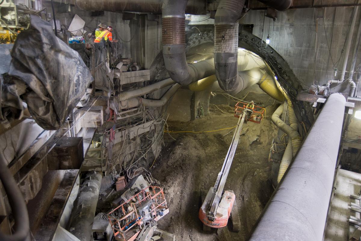 Workers and equipment inside underground transit station during construction or maintenance operations.