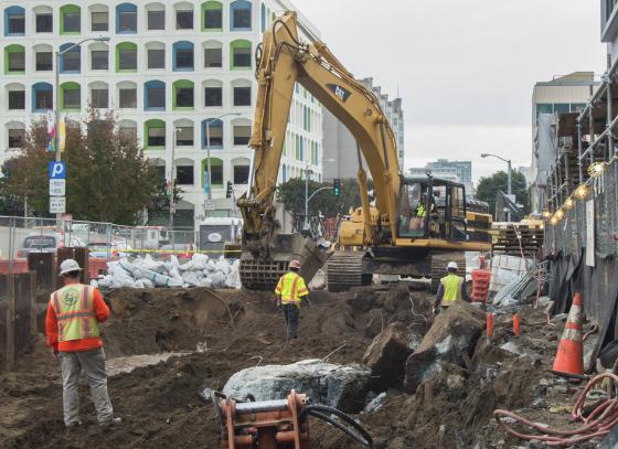 Excavator digs at 4th and Clementina streets for Yerba Buena/Moscone Station construction.
