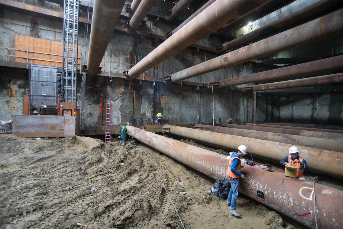 Workers install temporary steel bracing inside Yerba Buena Moscone Station headhouse during construction.