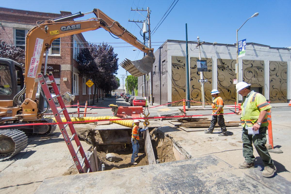 Construction crew works on underground utility trench at 4th and Welsh for Central Subway project.