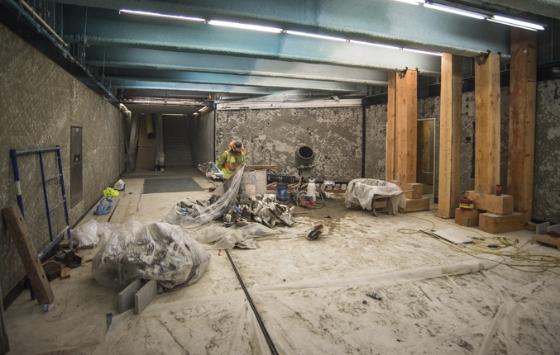 Underground transit entrance under construction with exposed concrete, wooden support columns, and construction materials on Ellis Street.