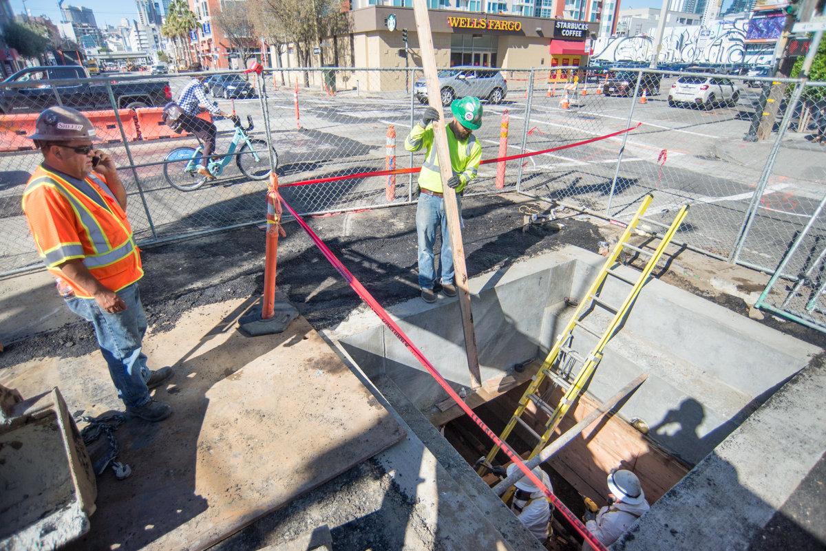 Workers remove wooden concrete forms from an excavated trench at 4th and Brannan Street.
