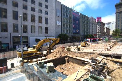 Construction site with excavator removing debris from Union Square Garage demolition in urban area.