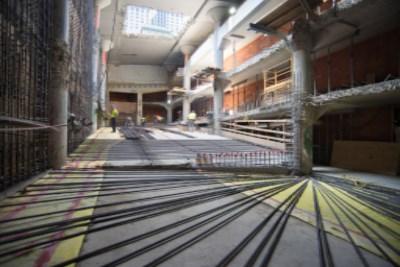Interior of Union Square Garage under construction with exposed concrete, rebar, and construction materials visible throughout the space.