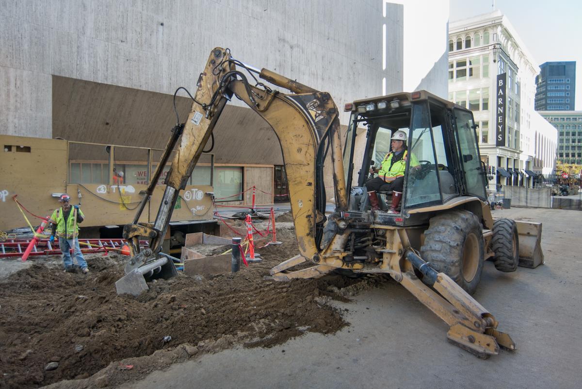 Construction crew operates backhoe during street restoration work on Stockton Street in downtown San Francisco.