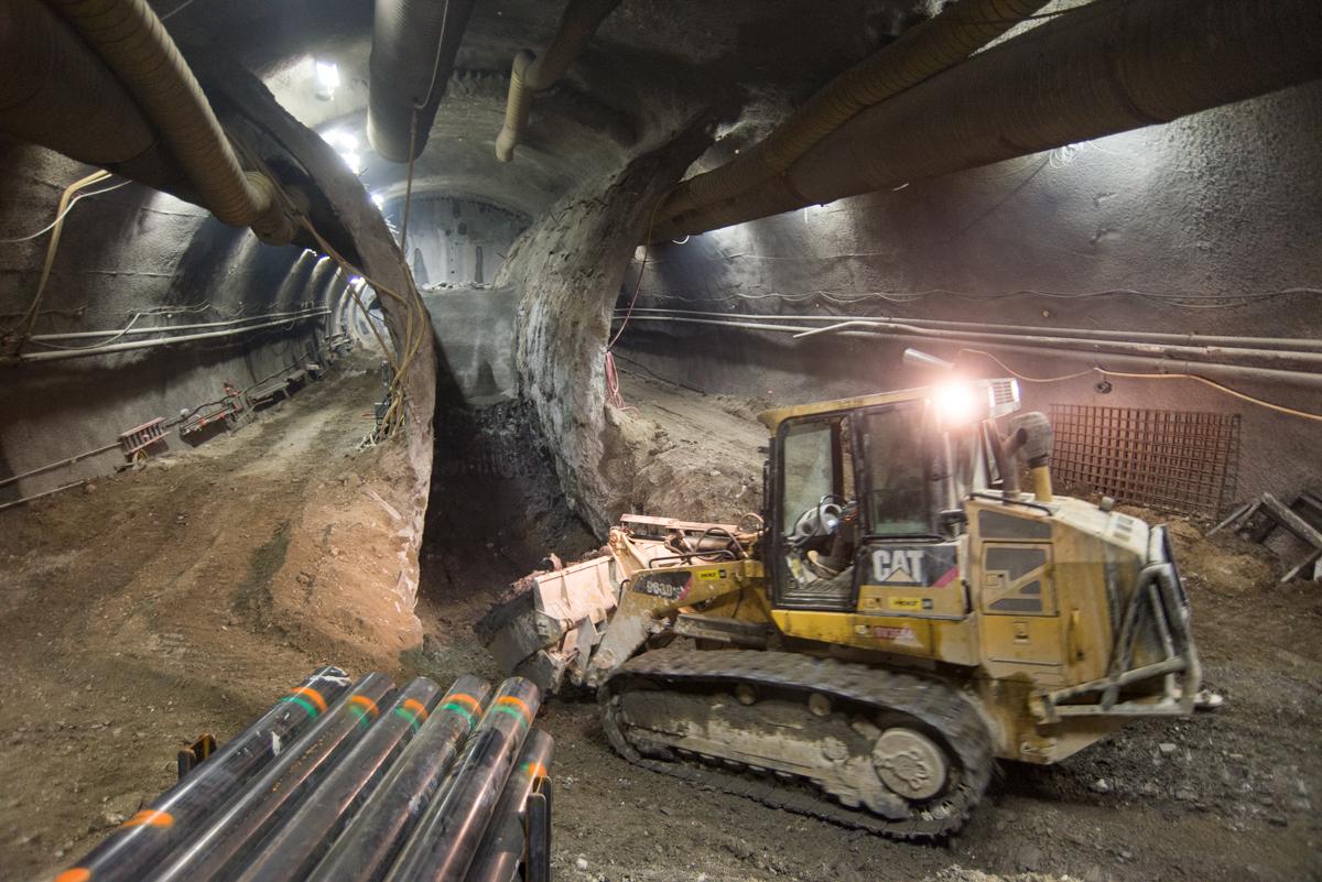 CAT excavator operates inside underground transit tunnel during construction work