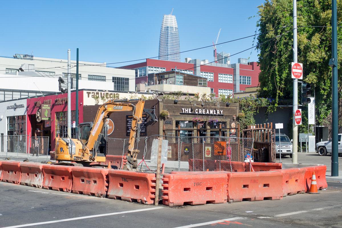 Construction equipment and barriers at Bryant and Brannan intersection during daytime utility upgrade work.