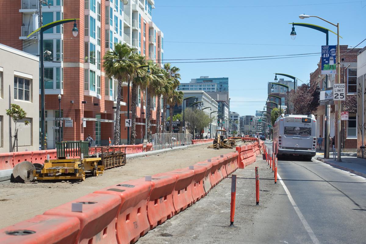 Construction barriers and equipment on 4th Street during roadway restoration project in urban area.