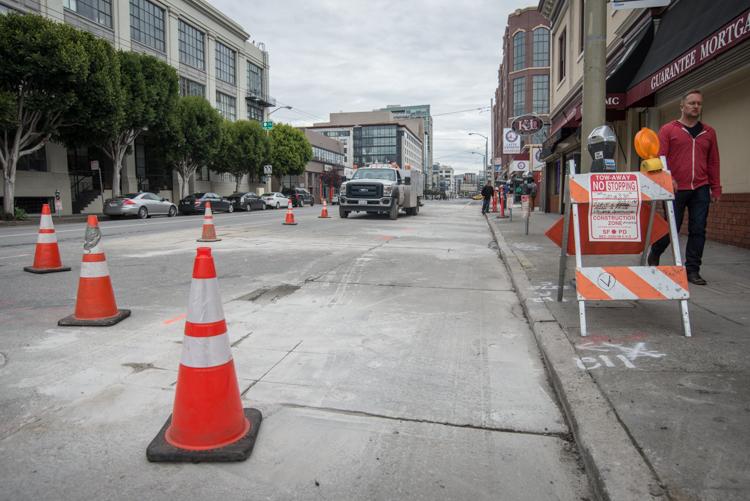 Construction cones and barriers block 4th Street during Central Subway utility work in San Francisco's SoMa district.