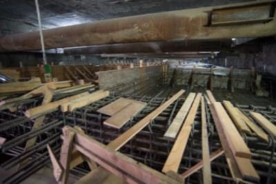 Construction site with wooden forms and rebar cages for transit station mezzanine floor.