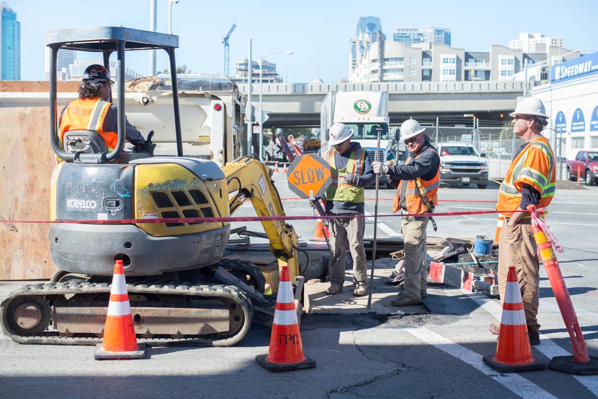 Construction crew removes wooden concrete forms from excavation site at 4th and Brannan Street.