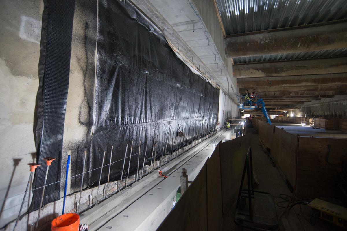Vinyl sheeting installed on east wall of underground transit station for waterproofing during construction.