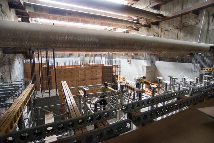Construction workers assemble concrete formwork and scaffolding for the Central Subway Concourse level.