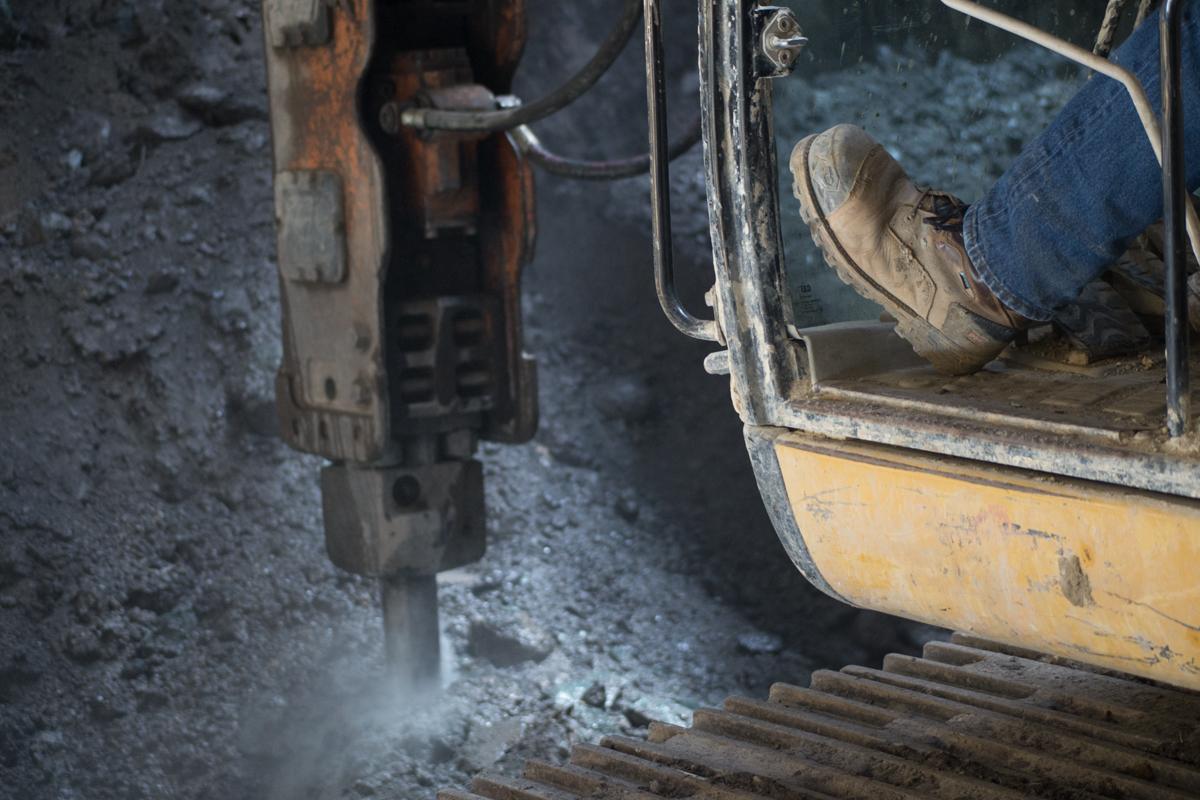 Construction jackhammer breaking up pavement on Stockton Street during transit station excavation work.