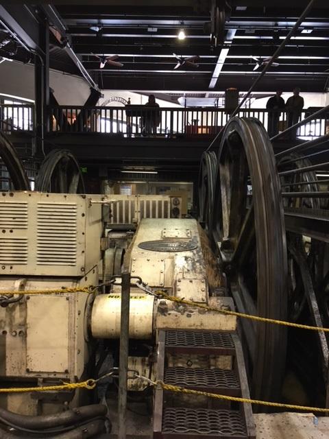 Vintage cable car gearbox and mechanical components in repair facility, showing wear and age.