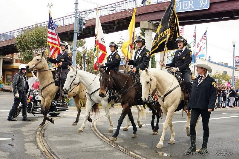 Sheriff's deputies on horseback carrying flags during Veterans Day Parade near Pier 39.