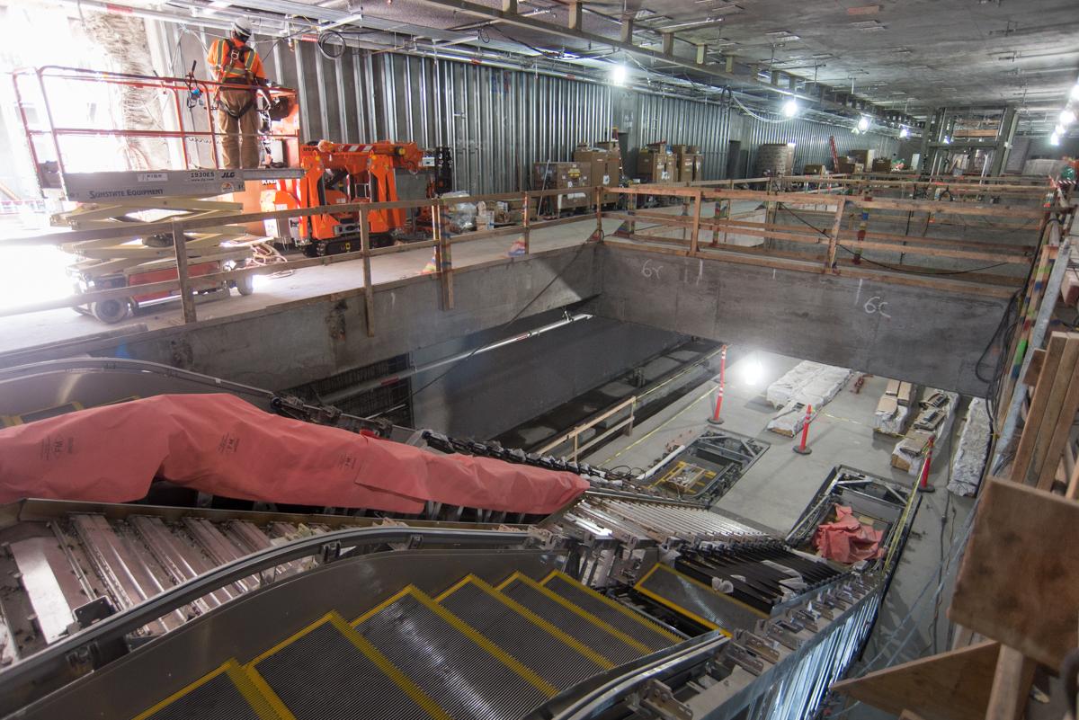 Central Subway station under construction with escalators and staircase installation in progress.