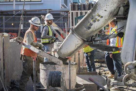 Construction workers pour concrete into a station wall form at the Yerba Buena/Moscone Station site.